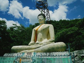 Low angle view of buddha statue against sky