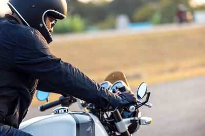 Side view of man riding motorcycle on road