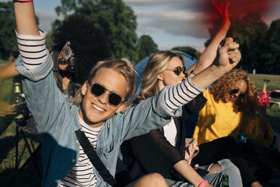 Happy young man enjoying with friends in music festival