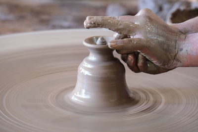 Cropped hand of person making pottery at workshop