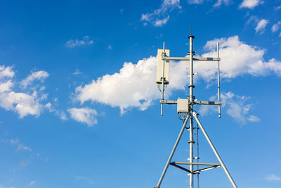 Low angle view of communications tower against blue sky