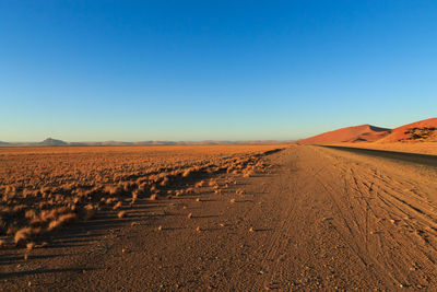 Scenic view of desert against clear blue sky