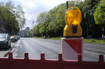 Road sign by cars on street in city