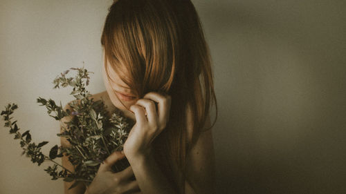 Portrait of woman against wall at home