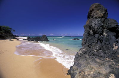 Scenic view of rock formations in sea against sky