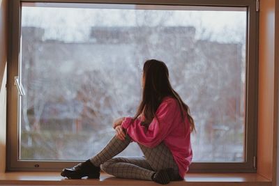 Woman looking through window