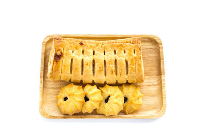 Pineapple pie and cookies in wooden plate on a white background