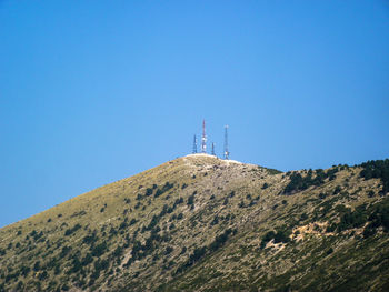 Low angle view of communications tower against clear blue sky