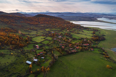 High angle view of field and houses against mountains