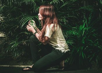 Young woman touching plant