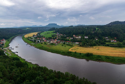 Scenic view of river amidst green landscape against sky