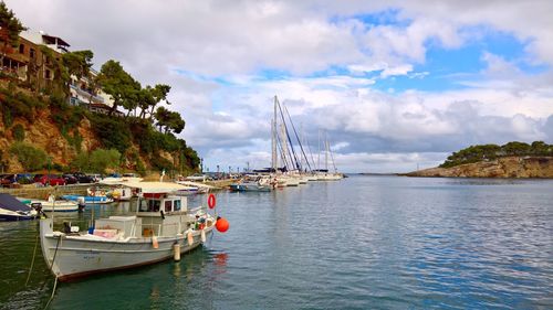 Sailboats moored in sea against sky