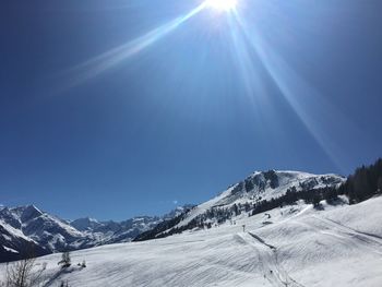 Scenic view of snowcapped mountains against sky on sunny day