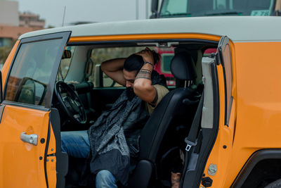 Man tying hair while sitting in car