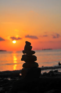 Close-up of stack of pebbles on beach during sunset