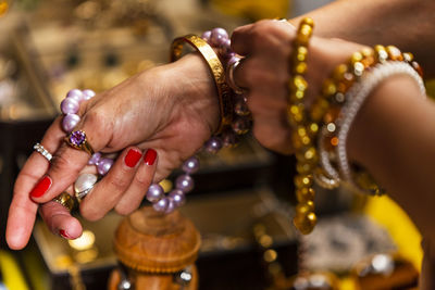 Cropped hands of woman holding jewelries