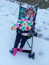 Portrait of cute girl on snow field during winter