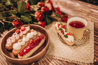 Plate with cakes and a cup of tea on a wooden table