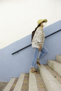 Side view of woman standing against wall