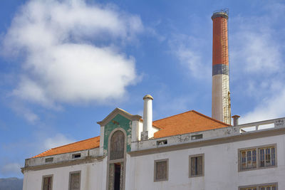Low angle view of old sugar factory against sky