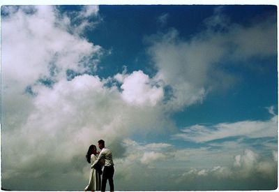 Couple standing against sky