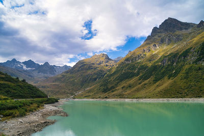 Scenic view of lake by mountains against sky