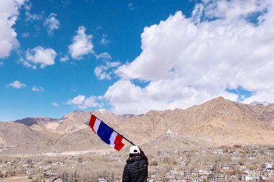 Low angle view of flag on mountain against sky