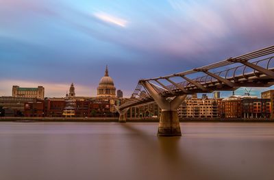 View of bridge over river in city against sky