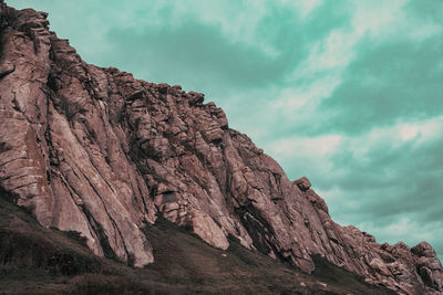 Low angle view of rock formation against sky