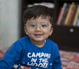 Portrait of boy wearing eyeglasses at home