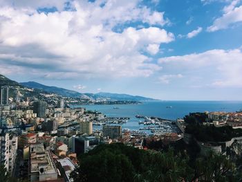 High angle view of city by sea against sky