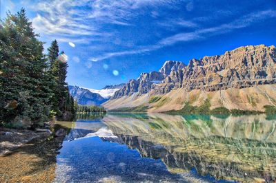 Scenic view of lake and mountains against blue sky