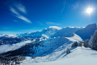 Scenic view of snowcapped mountains against blue sky