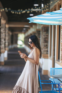 Smiling young woman looking away while standing in cafe