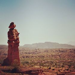 Statue on landscape against clear sky