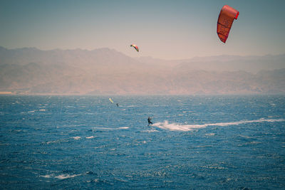 People kiteboarding in sea against sky