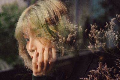 Close-up of thoughtful woman seen through window