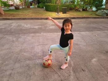 Portrait of happy boy with arms raised in park