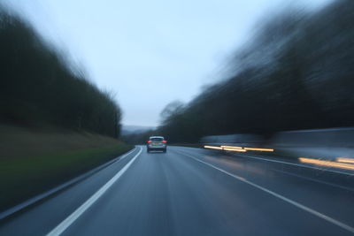 Car moving on road against sky