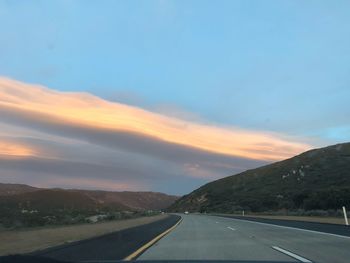 Empty road against sky during sunset