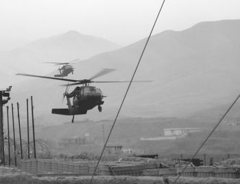 Overhead cable car over mountains against sky