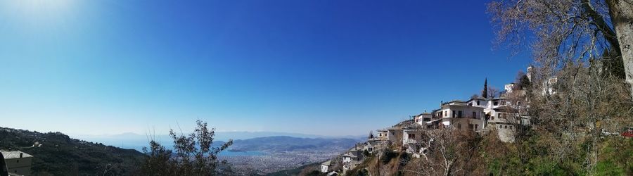 Panoramic shot of buildings against clear blue sky