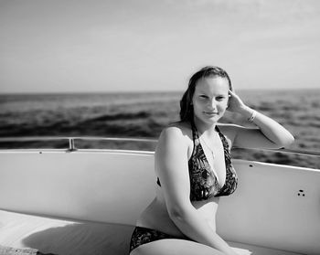 Portrait of woman sitting on boat in sea against sky