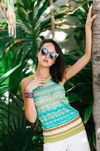 Portrait of young woman wearing sunglasses standing outdoors