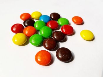 High angle view of multi colored candies against white background