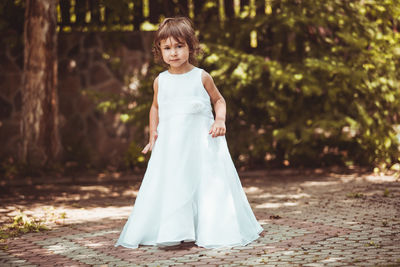 Full length of girl standing on land against trees