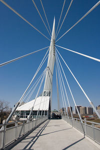 Low angle view of suspension bridge against clear blue sky