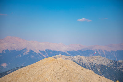 Scenic view of snowcapped mountains against blue sky