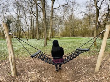 Happy woman resting and sitting hammock with snowdrops flowers in spring background 