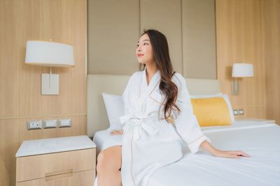 Young woman looking away while sitting at home